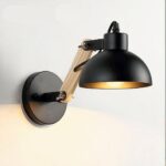 Adjustable LED wall light in wood and metal in black, to be hung on a wall and switched on