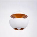 White chandelier in the shape of an open apple with gold interior. On a white background.