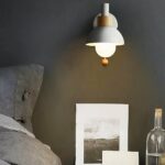 White bedroom wall light with switch above bedside table