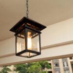 Hanging from the ceiling of a terrace, a black Japanese-style outdoor lantern can be seen lit up.