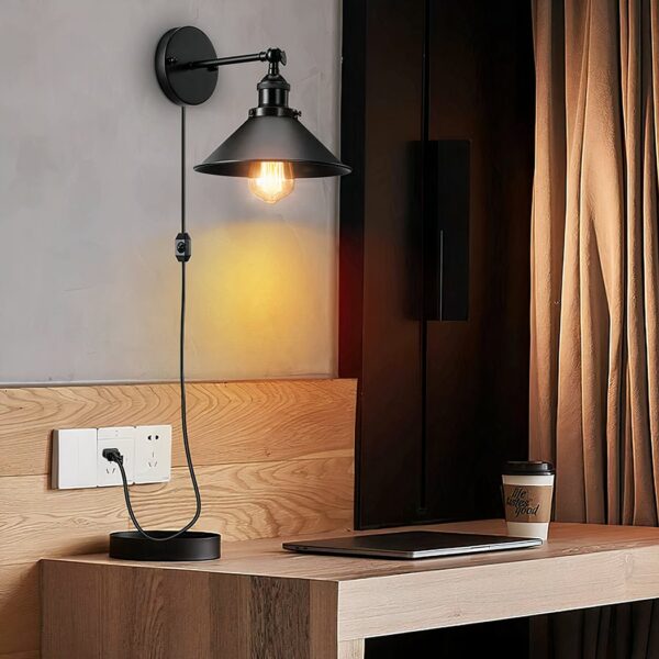 Vintage black wired wall light, displayed lit above a bedside table