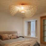 Bohemian-style adult bedroom chandelier in lighted rattan on beige background with bed