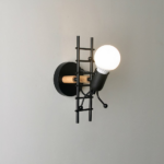 Children's wall lamp in the shape of a man with a metal ladder on a grey background
