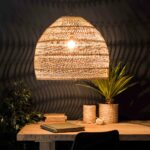 Chinese-style natural rattan pendant for dining room on black background with beige table