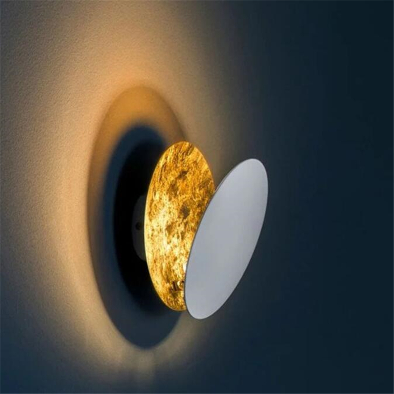 On a white background, a brown moon eclipse wall light is lit.