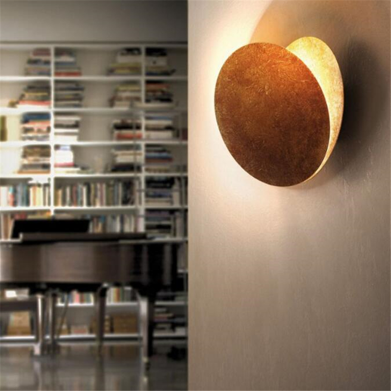 On a white background, a brown moon eclipse wall light is lit.