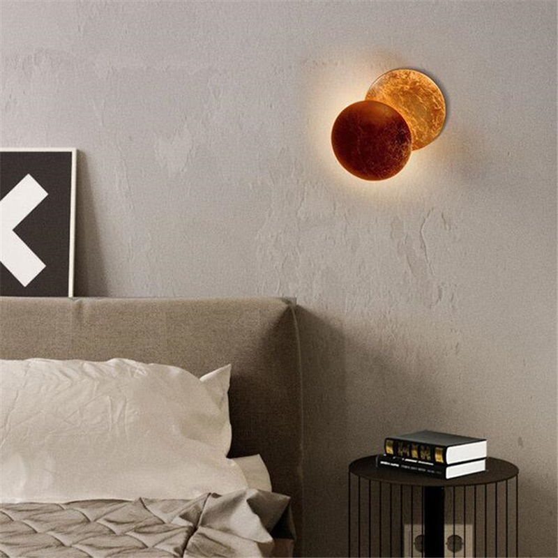 On a white background, a brown moon eclipse wall light is lit.