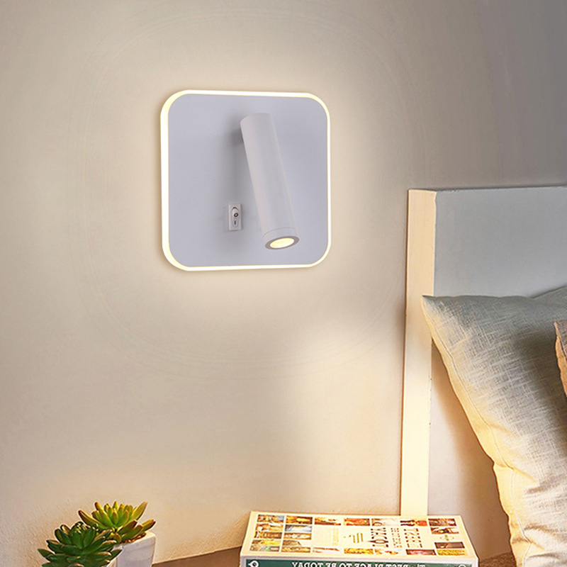 Flat white wall light with switch hanging above a bedside table