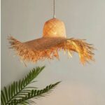 on a gray background, we see a suspension in the shape of a handmade straw hat made of raffia
