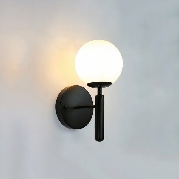 A black industrial-style wall light is lit against a white background.