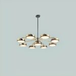 Suspended chandelier, with 9 light sources in the shape of a circle, one in the center and the other 8 distributed around it. The whole forms a kind of flower. On a pale green background.