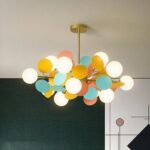 Minimalist, colorful children's chandelier with globes in a room with a dark green wall