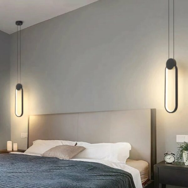 2 Minimalist black oval LED pendant above two bedside tables around a bed