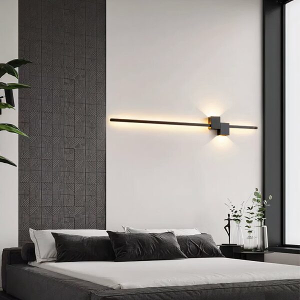 Modern, designer headboard wall light in black with yellow light, above a bed