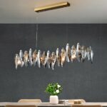 Modern dining room chandelier in crystal and stainless steel on grey background