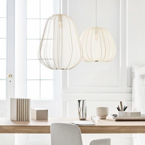 Round, tiered Japanese suspension lamp in white fabric above a simple wooden burau