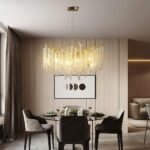 Modern kitchen chandelier with crystal raindrop design on beige background in a room with armchairs