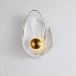 A white, marbled and gilded shell-shaped mural is set against a white background.