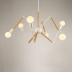 Spider chandelier, made of white metal rods and wood, with a bulb at the end of each rod. Suspended, a white wall in the background.