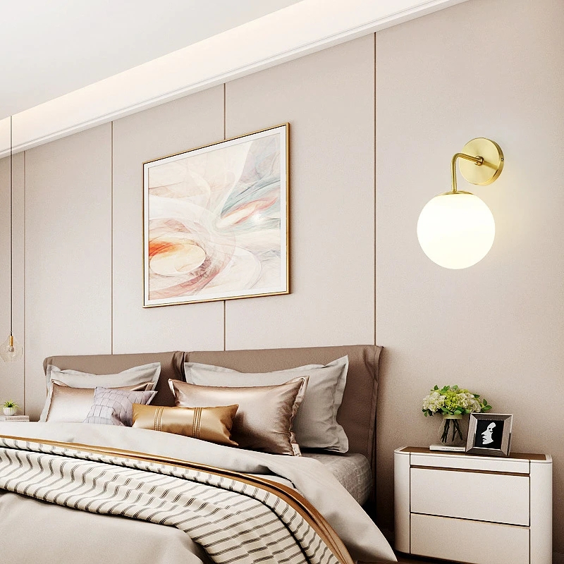 Round wall light in glass and gold metal for a bedroom