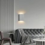 Scandinavian strillée wall light with double white illumination shown installed on a wall above a sofa
