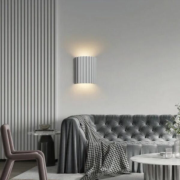 Scandinavian strillée wall light with double white illumination shown installed on a wall above a sofa