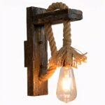 Vintage industrial wall light in hemp wood, lit on a white background