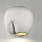 Hanging chandelier with minimalist artistic design, a kind of white pottery, with a light bulb lit inside. Like an upside-down hanging vase. On a gray background.