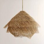 Hanging straw chandelier in the shape of a hut, covered with brushed-effect straw. On a beige background.