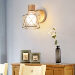 Modern LED wall light with geometric iron cage on grey background with objects on a piece of furniture