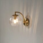 Nordic minimalist LED wall light in glass and metal on a grey background
