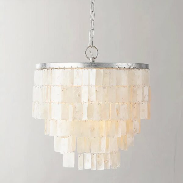Mother-of-pearl pendant suspended by a silver-plated chain. Composed of a round silver-plated frame adorned with flat rectangular mother-of-pearl beads forming a cluster. On a gray background.