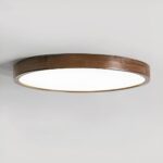 Round LED chandelier in wood and acrylic, glued to the ceiling. Grey background.