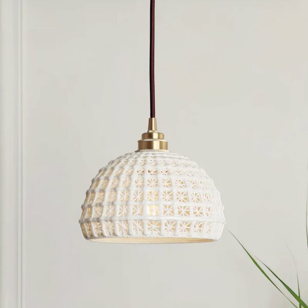 Original Scandinavian-design white pendant hanging from the ceiling and in front of a white wall.