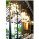 a long salon features wrought-iron chandeliers in the shape of black birdcages