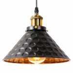 Chandelier with metal shade. Black on the outside and gold on the inside with hammered round motifs. The top of the socket is gilded, the bulb is lit. White background.