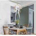 in a kitchen with gray and white tones, we see a birdcage suspension with its bird on top in white and gold origami