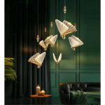 in a dark brown-green living room, we see a golden, transparent butterfly-shaped hanging lamp