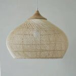 Hand-woven bamboo bedroom chandelier in the shape of a hat on a gray-green background.