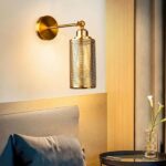 in a bedroom, above a bed, we see an industrial-style gold wall light