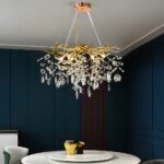 Large, modern, majestic chandelier with crystal branches and pendants suspended from the ceiling and above a dining room table.