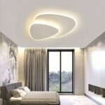 Modern white design triangle living room ceiling light fixed to the ceiling of a bedroom and lit.