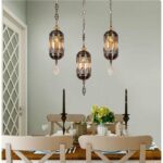 in a dining room, above a table, we see a glass suspension with black motifs in the Moroccan style