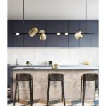in a modern kitchen, we see a beautiful Scandinavian minimalist black suspension with gold circles above the worktop