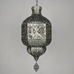 on a light grey background, we see a metal suspension carved in the Moroccan style