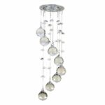 Silver ceiling chandelier with transparent glass water droplets suspended by wires at different heights to create a spiral effect.