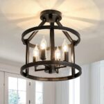 Black chandelier-shaped ceiling light with 4 light bulbs in the center. They are in a structure with 2 black metal circles. The top circle is held by black metal bars to a round support fixed to the ceiling. At the bottom, behind it, we see windows with white frames.
