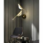in a dark-gray living room, a wall sconce featuring a pair of birds on a golden branch