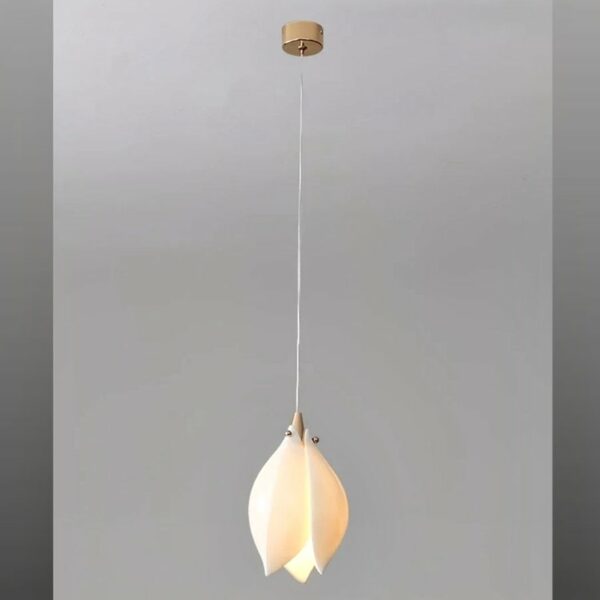 White magnolia-shaped ceramic flower hanging from the ceiling, lit on a gray background.